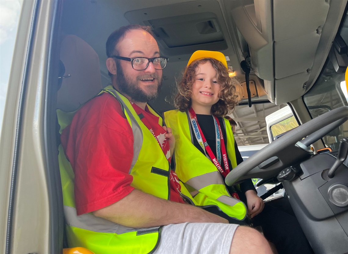 Five-year-old Euan and dad Sam sitting in the cabin of an Onkaparinga Council waste truck.