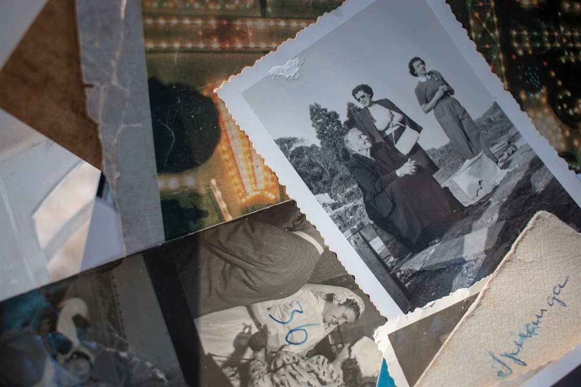 A random assortment of black-and-white family photos on a tabletop.