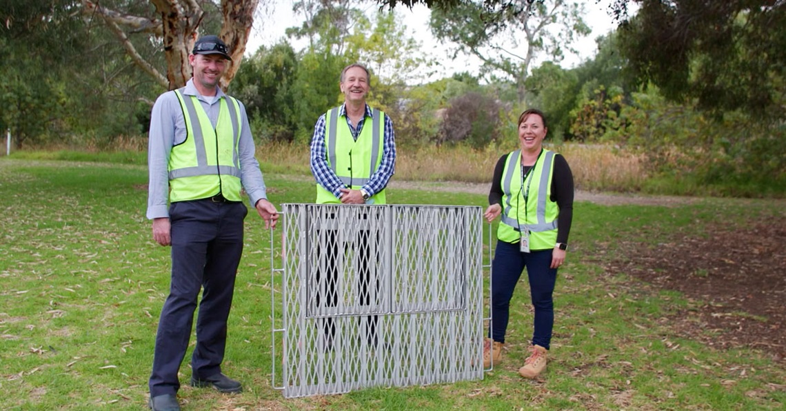Council staff pose with the Smart Plate in a grassy reserve.