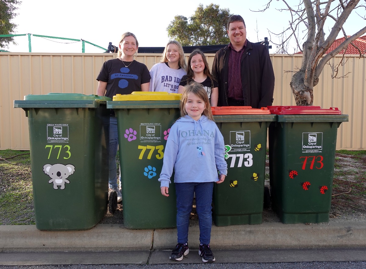 Family Alexa, Mikayla, Indy, Toni and Tim alongside bins covered with stickers.