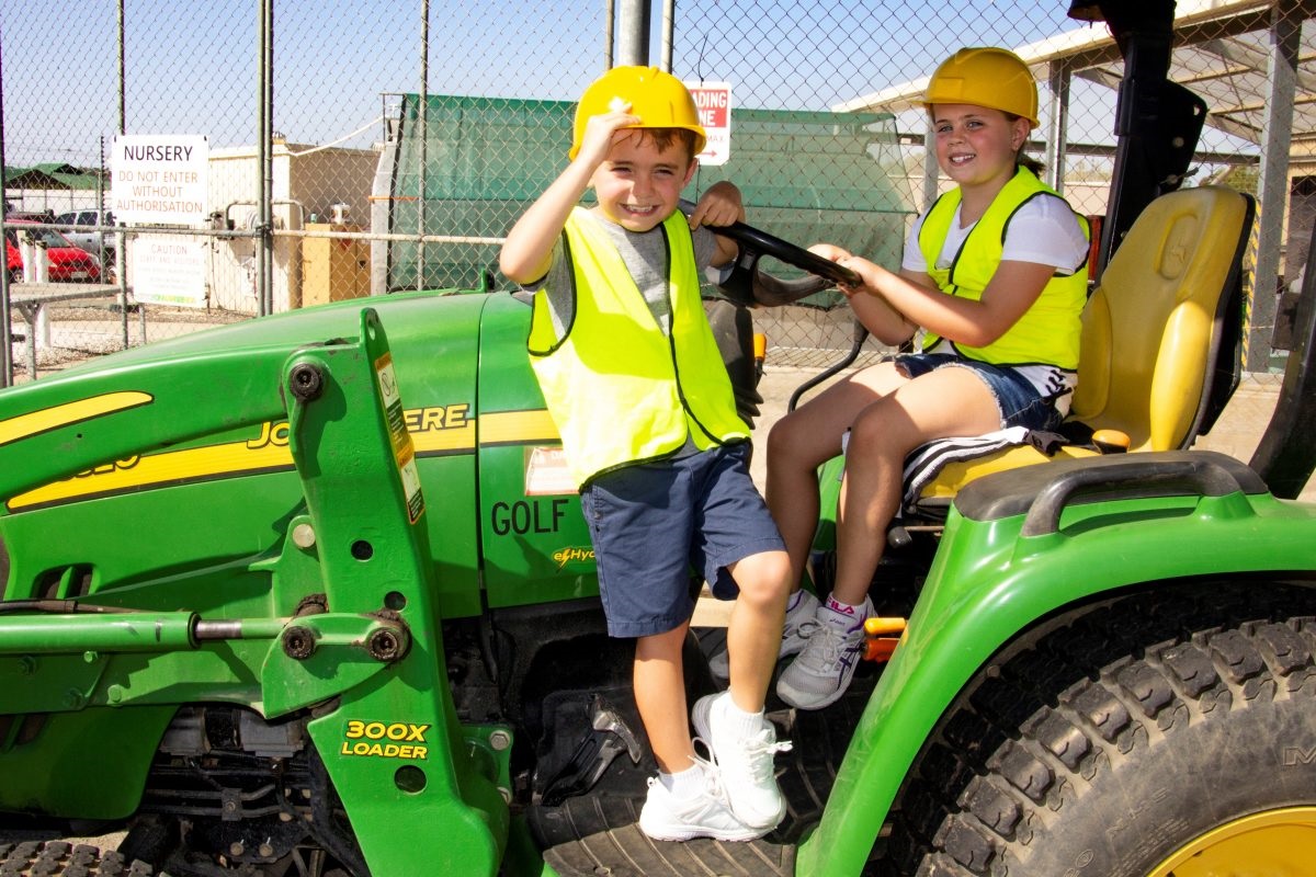 Aiden and Lia sitting on John Deere 300x loader truck