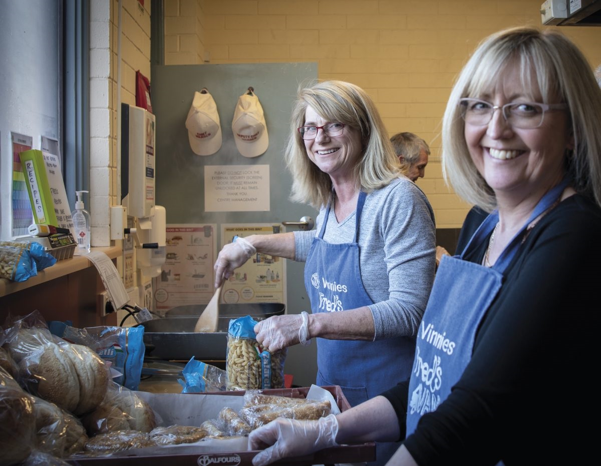 Mary Dittmar helps prepare dinner for people experiencing hardship; take-home sandwiches; Peter Sheerat, Tracy Harper and Helen Telford cook up a storm with other volunteers.