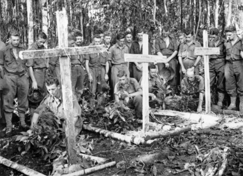 Australian soldiers pay tribute to three comrades killed in battle, including Harold Rice, in New Guinea, 28 October 1943. Photo: Gordon Herbert Short
