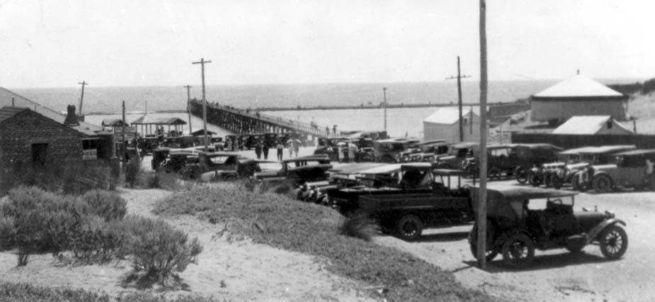 A black and white photos of rows of cars parked in front of the Port Noarlunga jetty in the 1920s.
