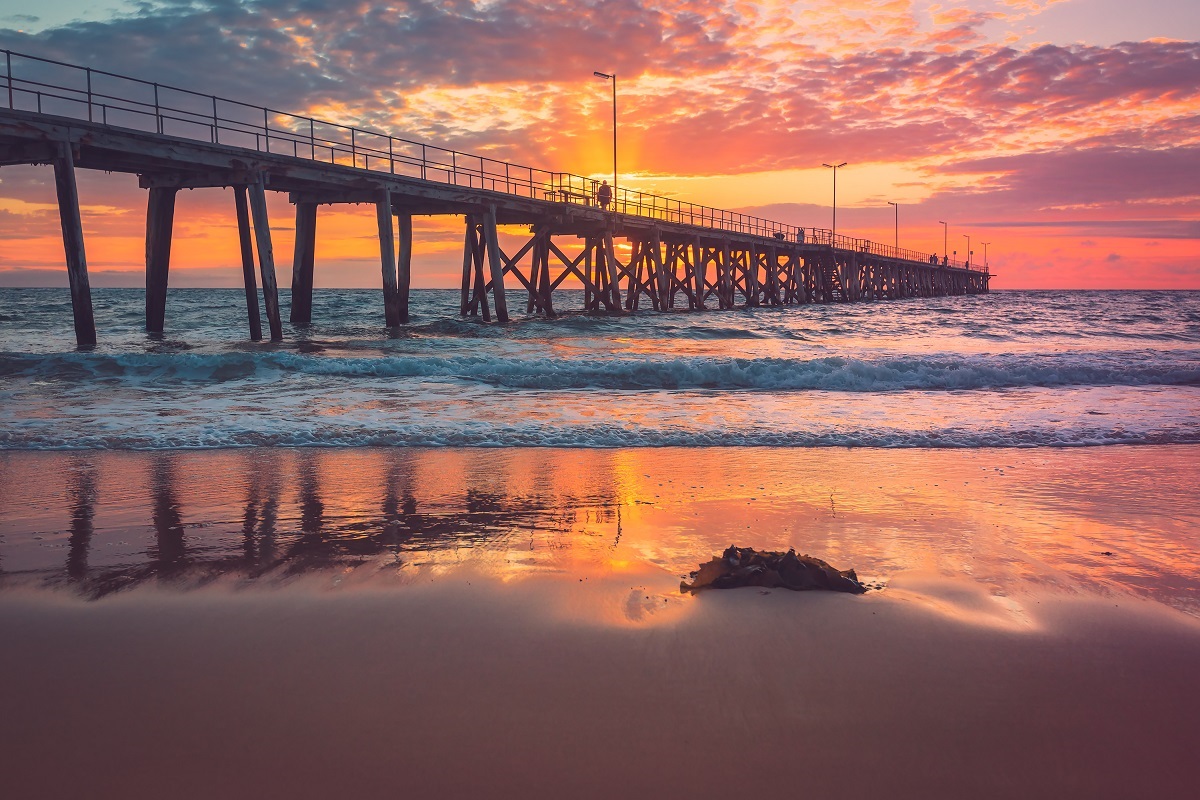 The view of Port Noarlunga jetty from the beach at sunset.