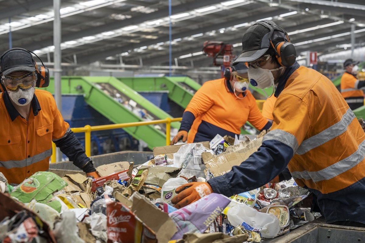 Employees at the new SMRF filter recyclables on a conveyor belt.