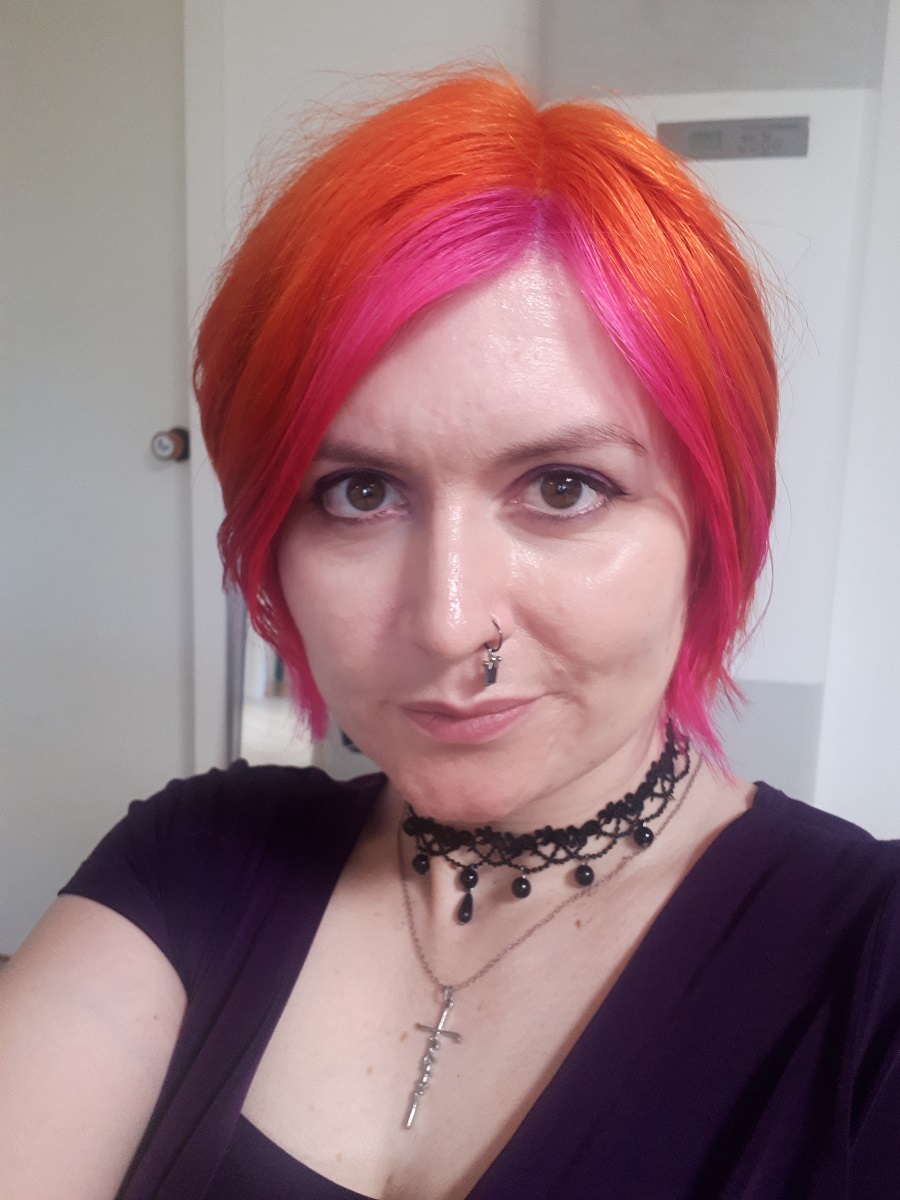 Season takes a selfie with orange-pink hair.