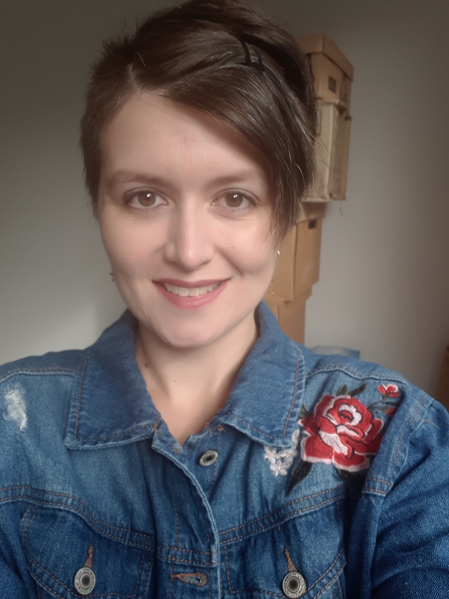Season takes a selfie smiling wearing a blue denim jacket.