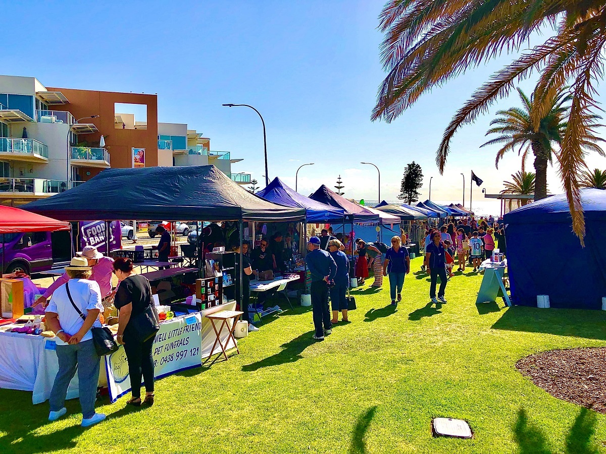 Market goers and stalls line Rotary Park at Christies Beach.