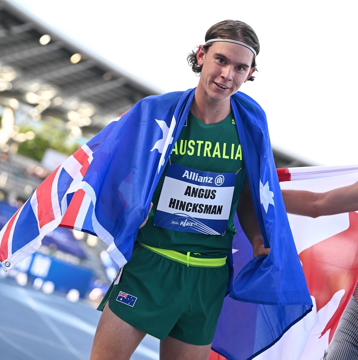 Maslin Beach's Angus Hincksman smiles while draped in an Australian flag after winning his bronze medal.