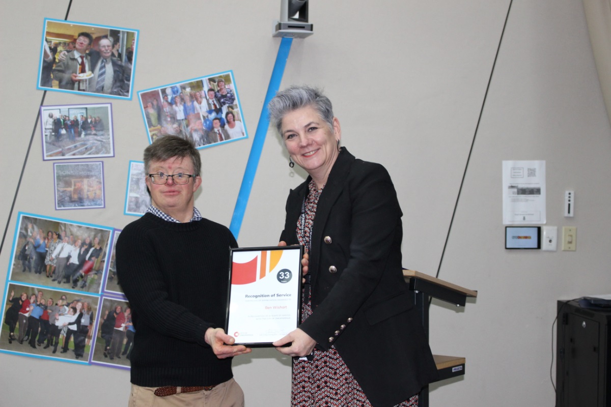 Ben Wishart and Acting CEO Julia Grant hold Ben's certificate and smile for the camera.
