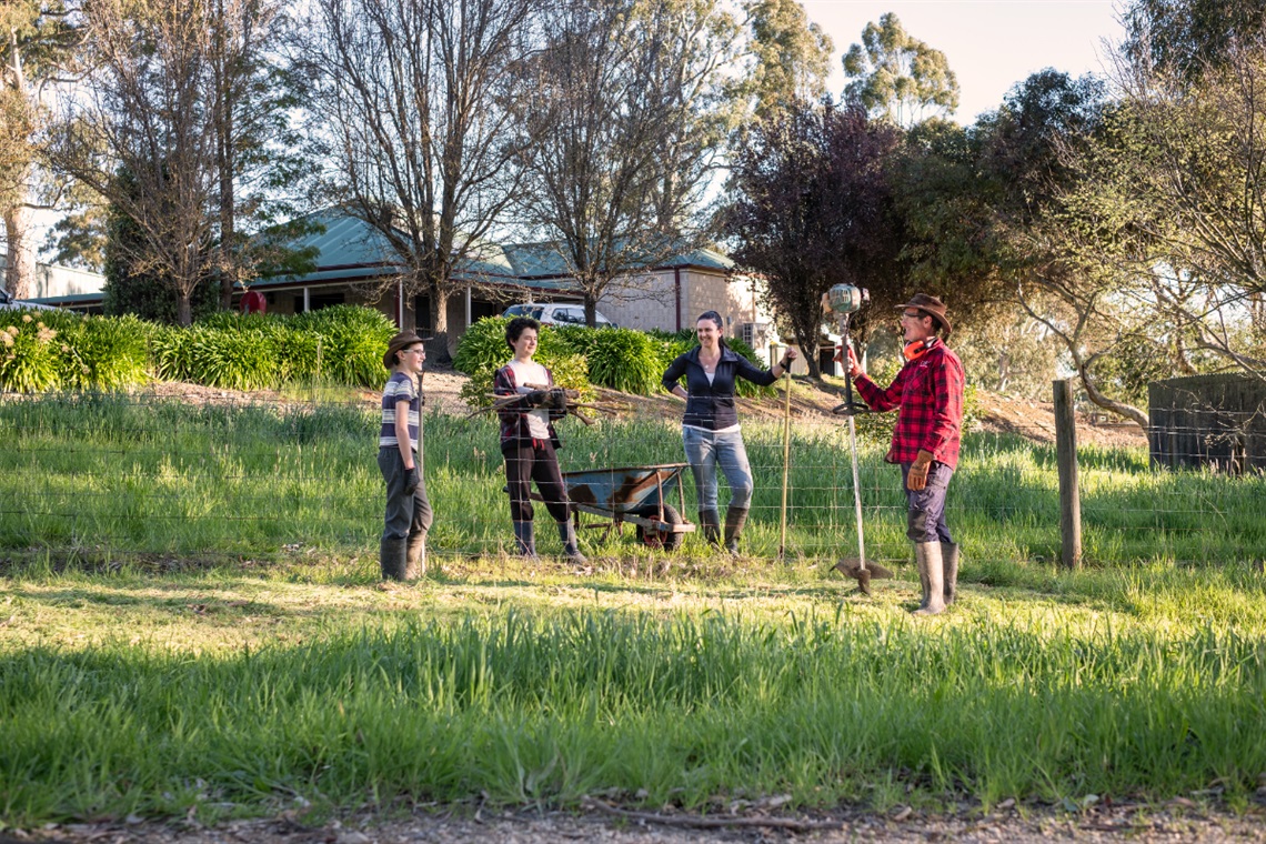 The Ayles family stand alongside a fence next to their property with as they get ready to prepare their property for bushfire season.
