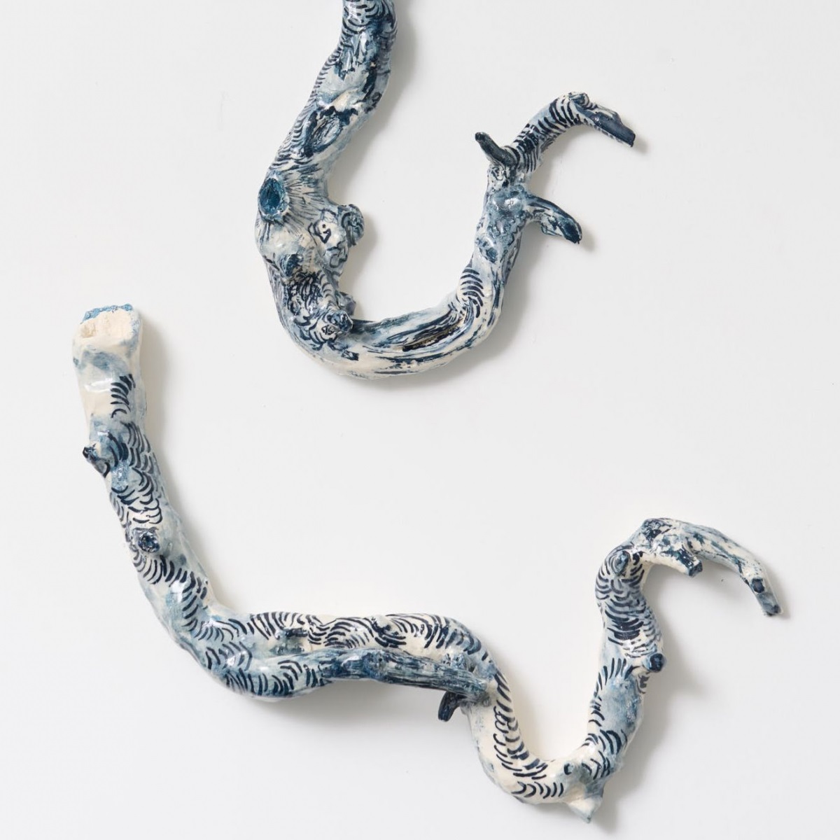 A close-up image of some detailed botanical ceramic works on a white background.