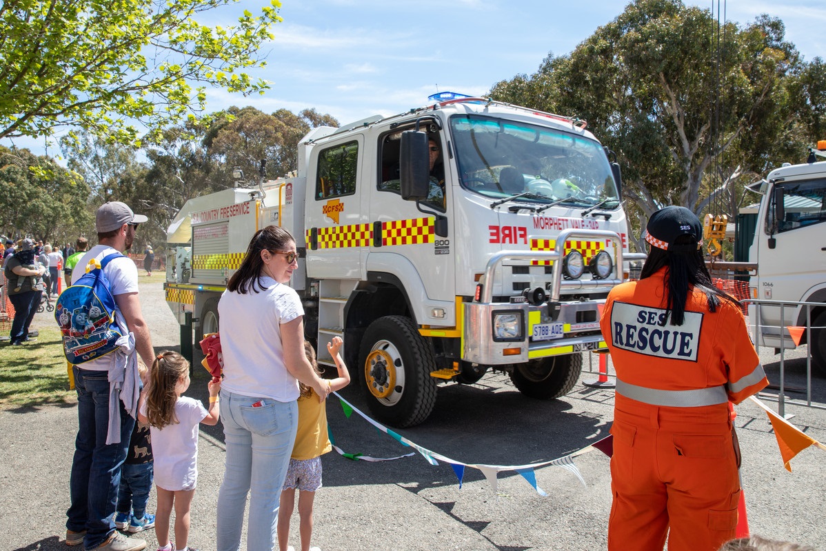 A crowd looks at a white CFS truck.
