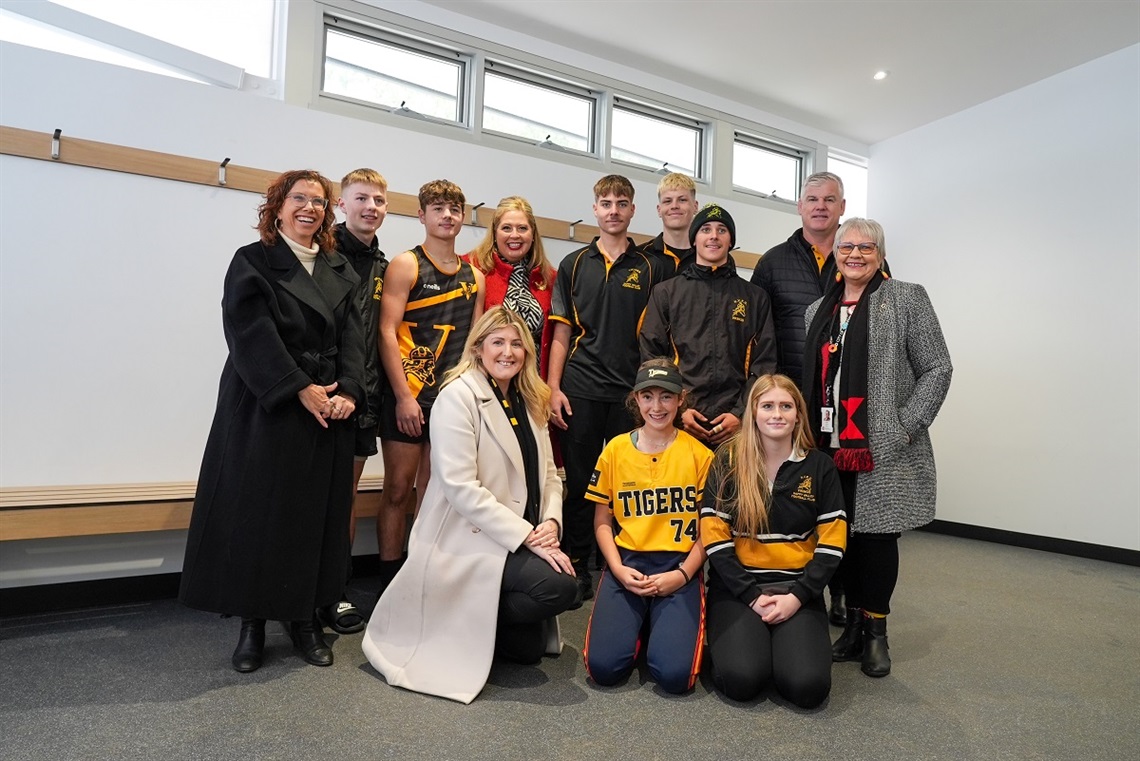 Representatives from Happy Valley sporting clubs smile alongside Onkaparinga's mayor and local MPs in the new Happy Valley Sports Park change rooms.