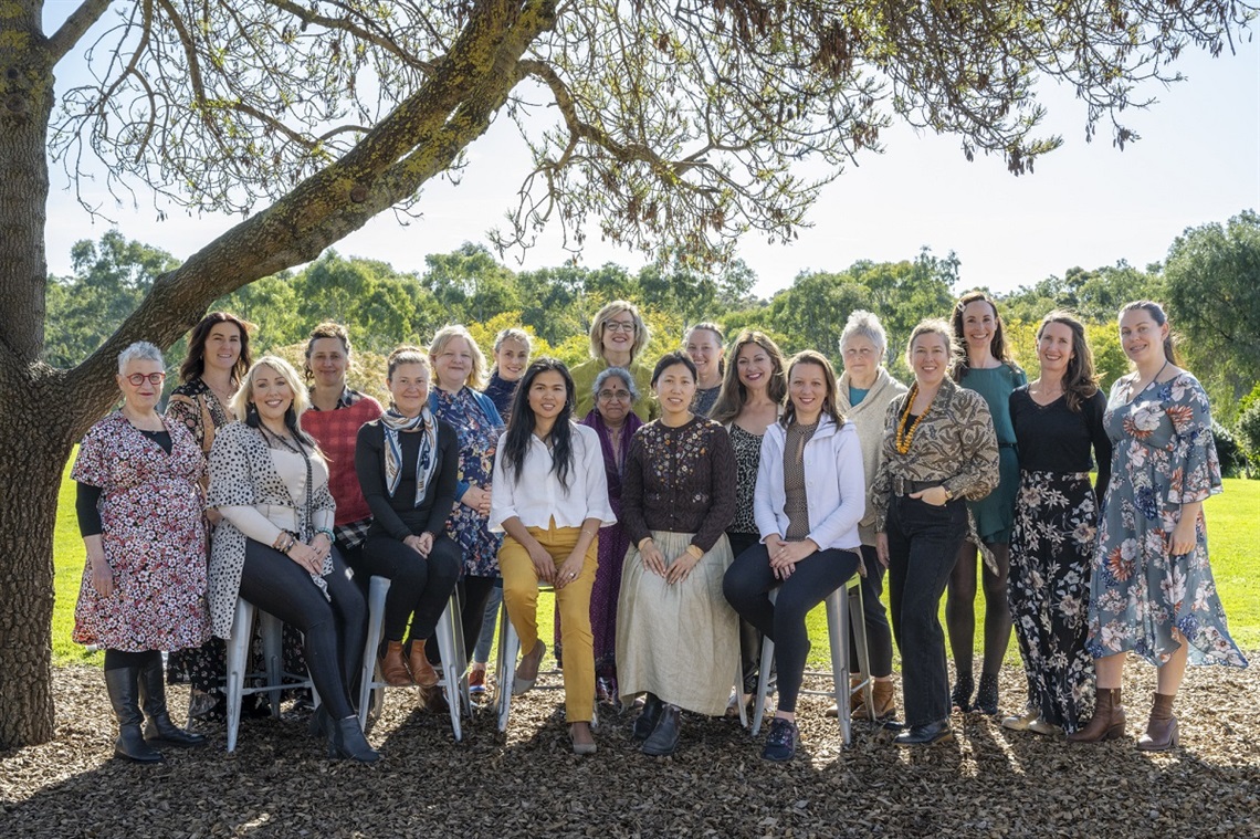The eighteen participants and program leader of the 2023 Leadership Onkaparinga cohort standing alongside one another and smiling beneath a large tree.