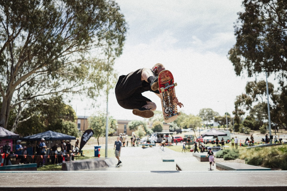 A skater does a big air up a ramp.