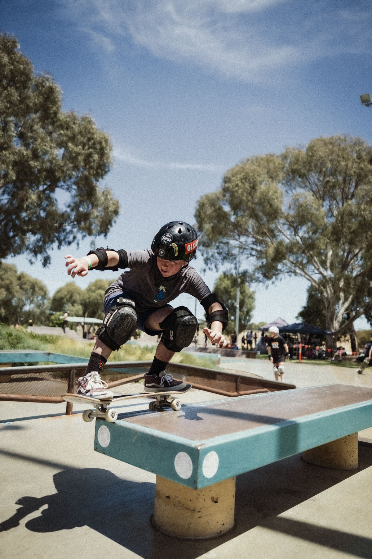 A young skater grinds his skateboard along the coping.