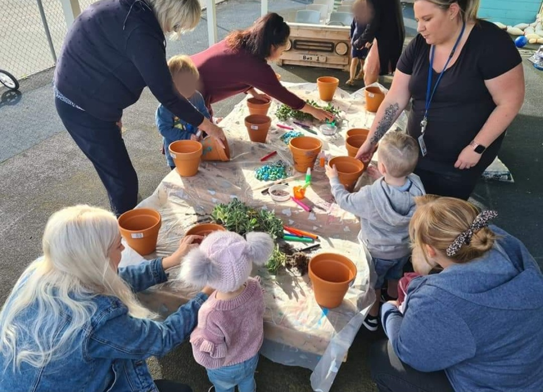 Parents, children and volunteer Sam Blight decorate pots at a Seaford Community Centre playgroup session.