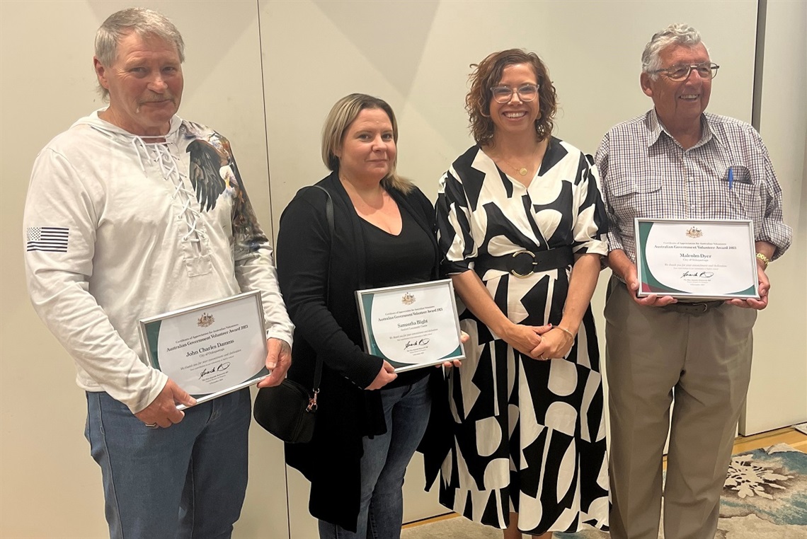 A photo of volunteers John Damms, Sam Blight and Mal Dyer smile with their awards alongside Amanda Rishworth MP.