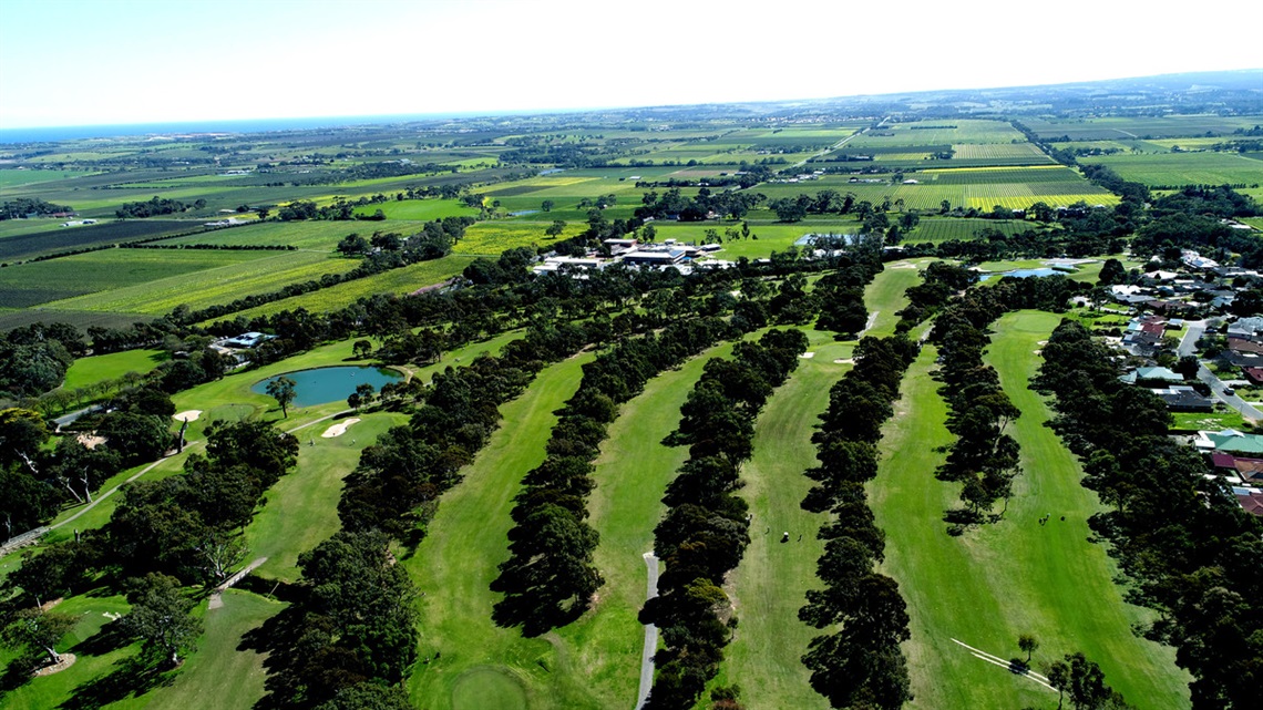 An aerial view of the green fairways and surrounding trees of the Willunga Golf Course.