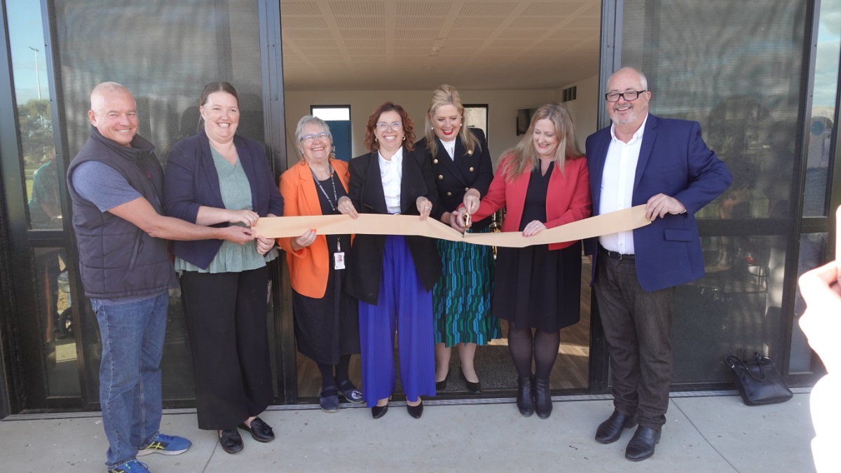 Representatives from local, state and federal government smile as they cut a gold ribbon to officially open the new Aldinga Sports Park upgrades.