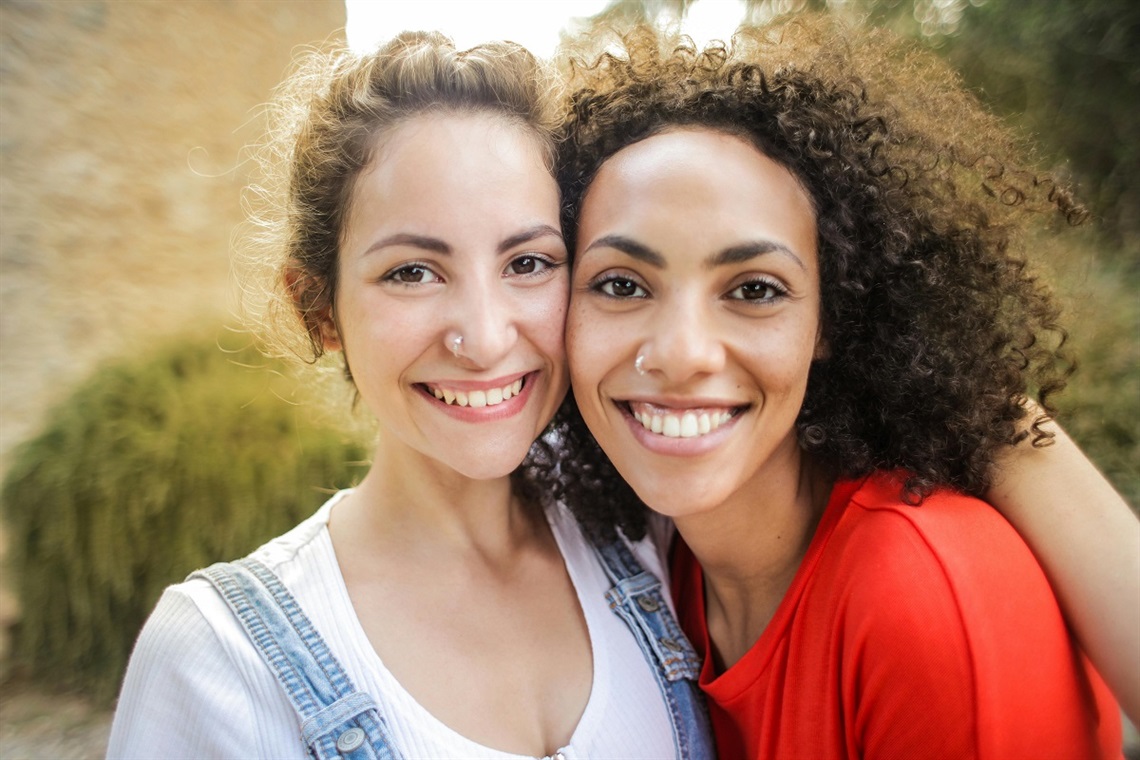 Two women smile at the camera.