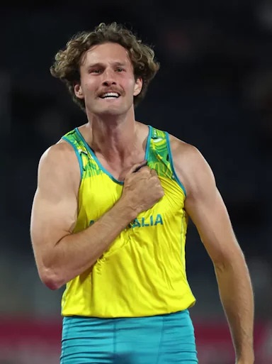 Pole vaulter Kurtis Marschall beats his chest with happiness wearing his Australian athletics outfit.