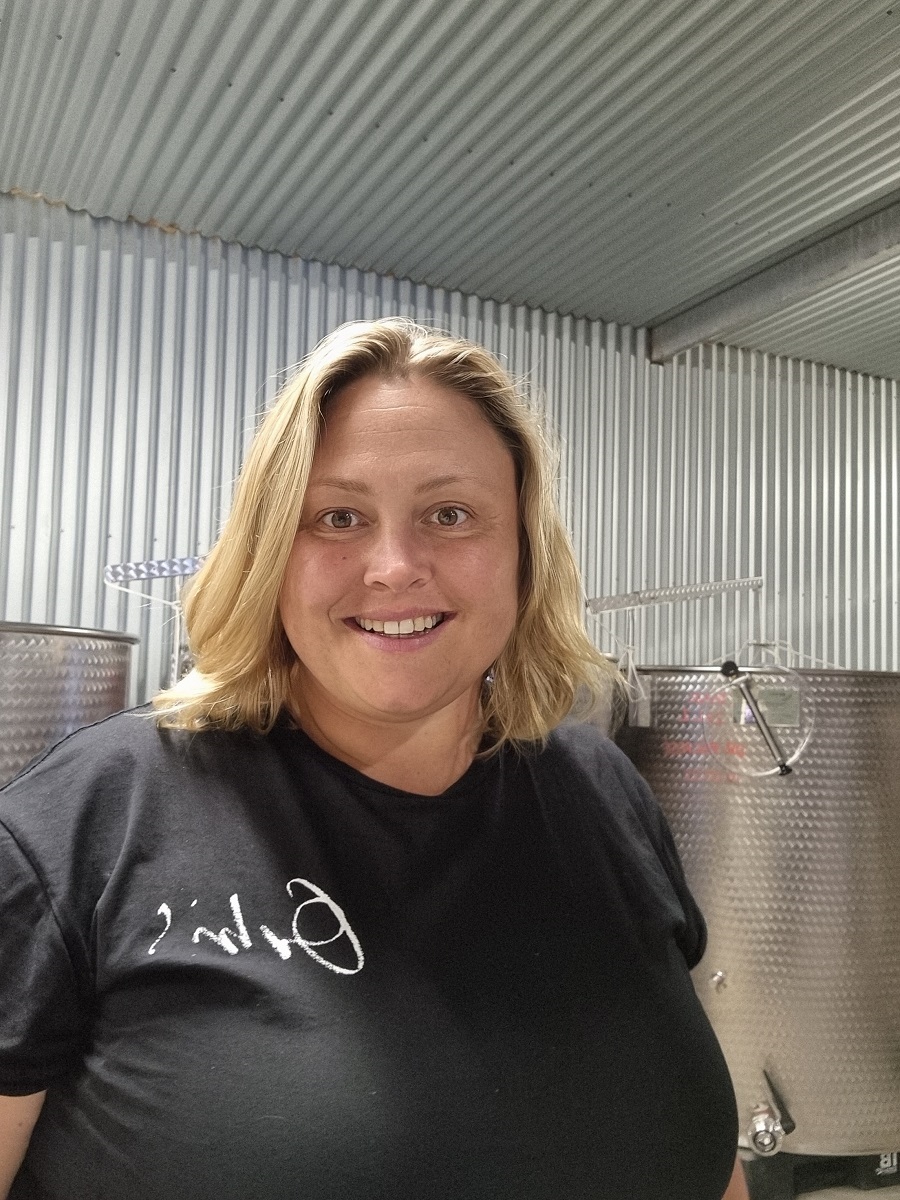 Lauren Langfield from Orbis Wines smiles at the camera in a black T-shirt.