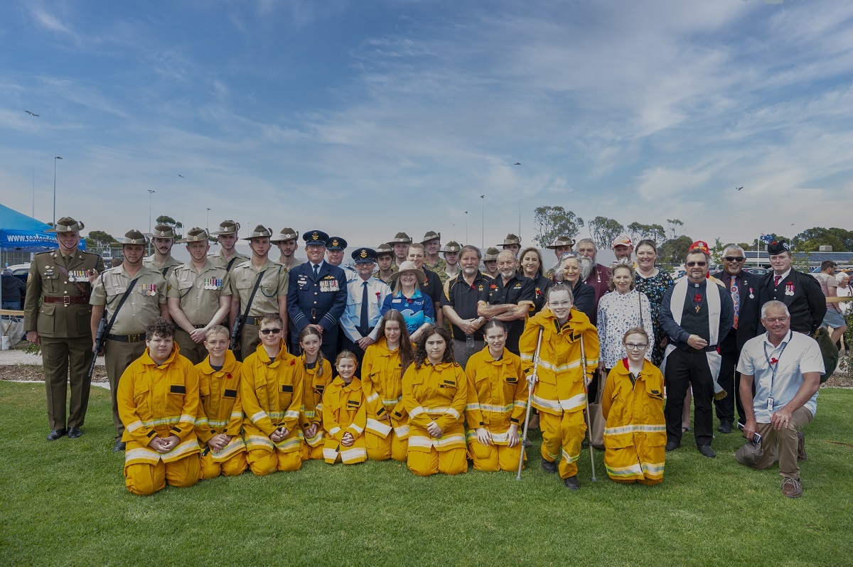A crowd of people smiles for the camera at the Aldinga War Memorial opening.