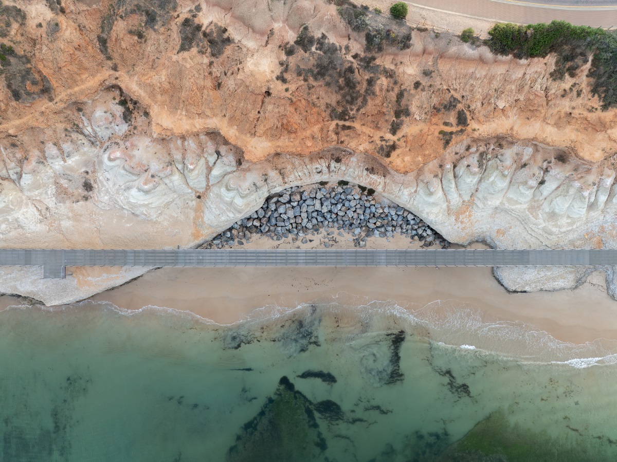 A view from atop the Witton Bluff Base Trail boardwalk showing the clear water, rocks and cliffs.