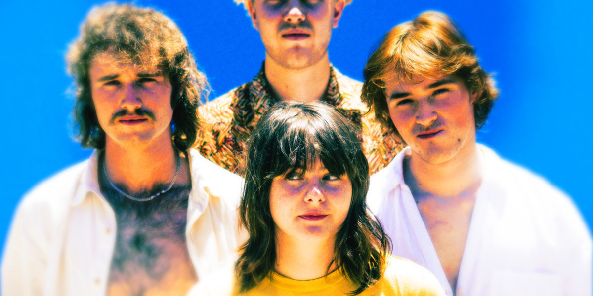 A photo of young four-piece band, Molly Rocket, wearing white clothing with a blue background.