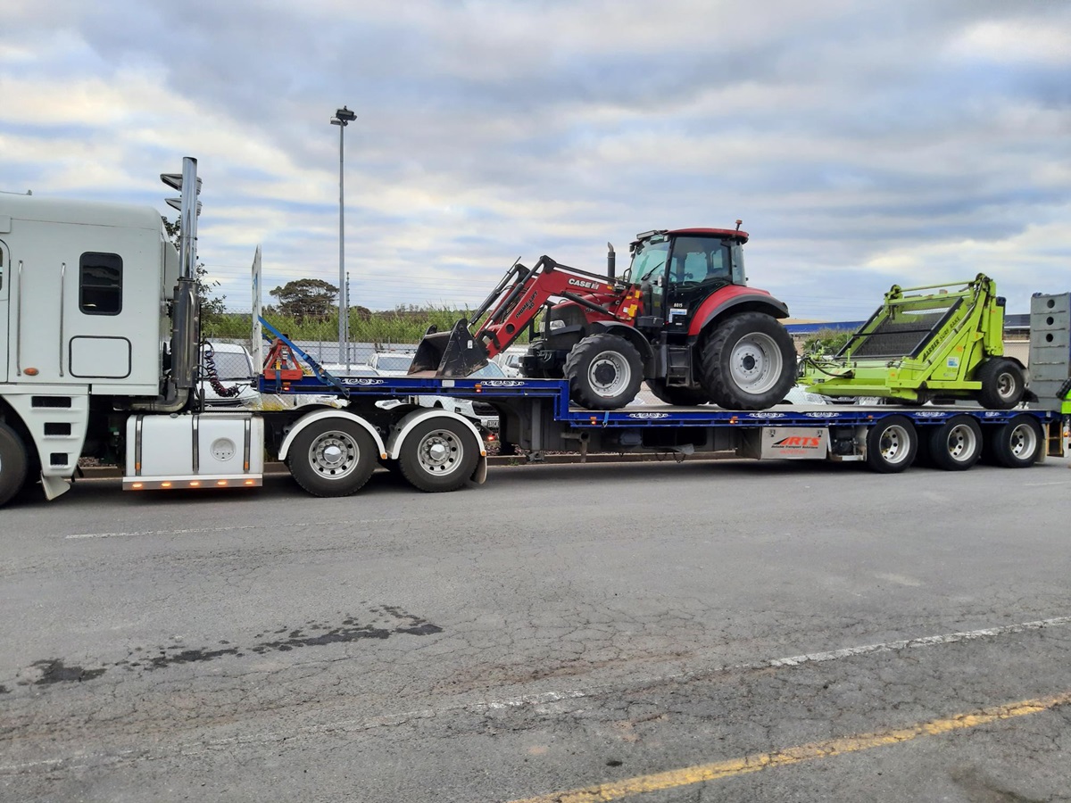 Onkaparinga's beach rake machinery on the back of a truck behind a red tractor.