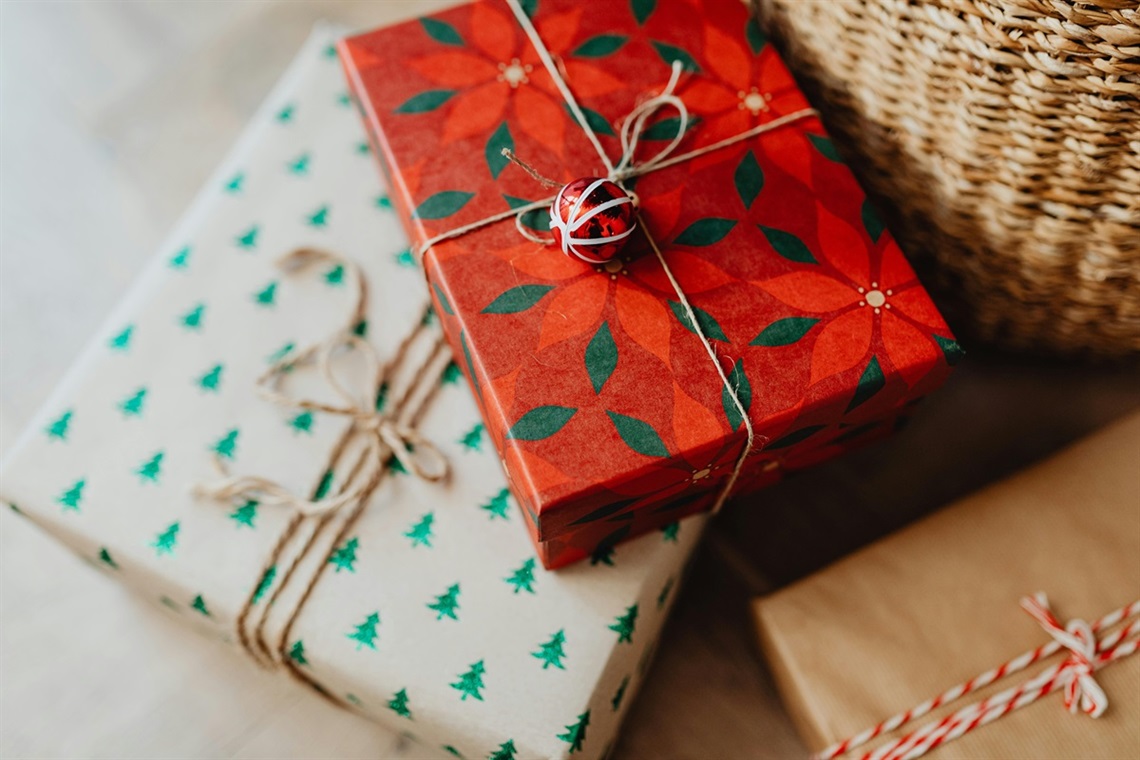 A close-up photo of 2 wrapped presents with Christmas-themed wrapping paper.