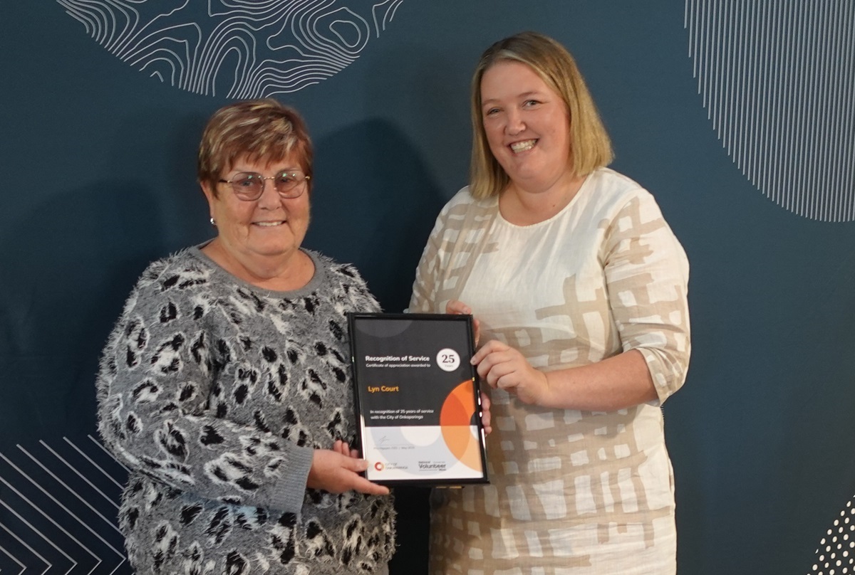 Volunteer Lyn Court and Councillor Lauren Jew hold Lyn's recognition of service certificate recognising 25 years.