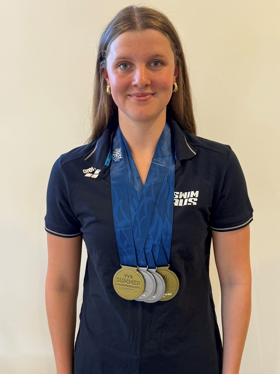 Molly Walker wears a blue polo top and four swimming medals around her neck.