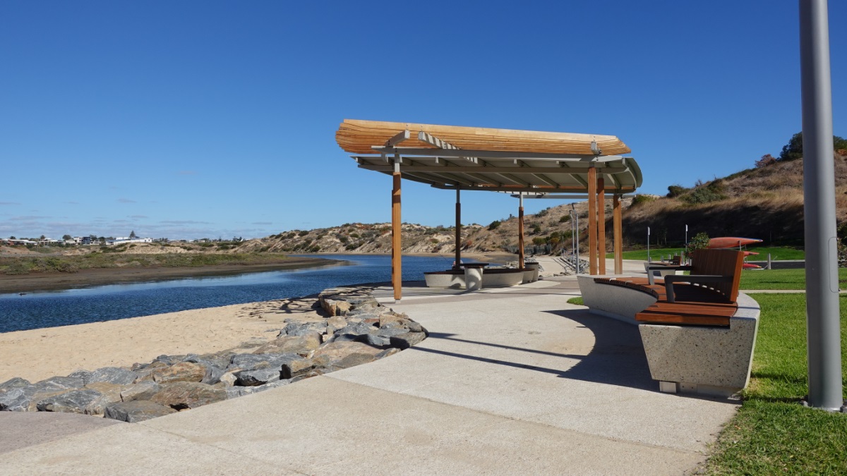 A view from the Wearing Street riverbank showing a shade structure and bench seats.