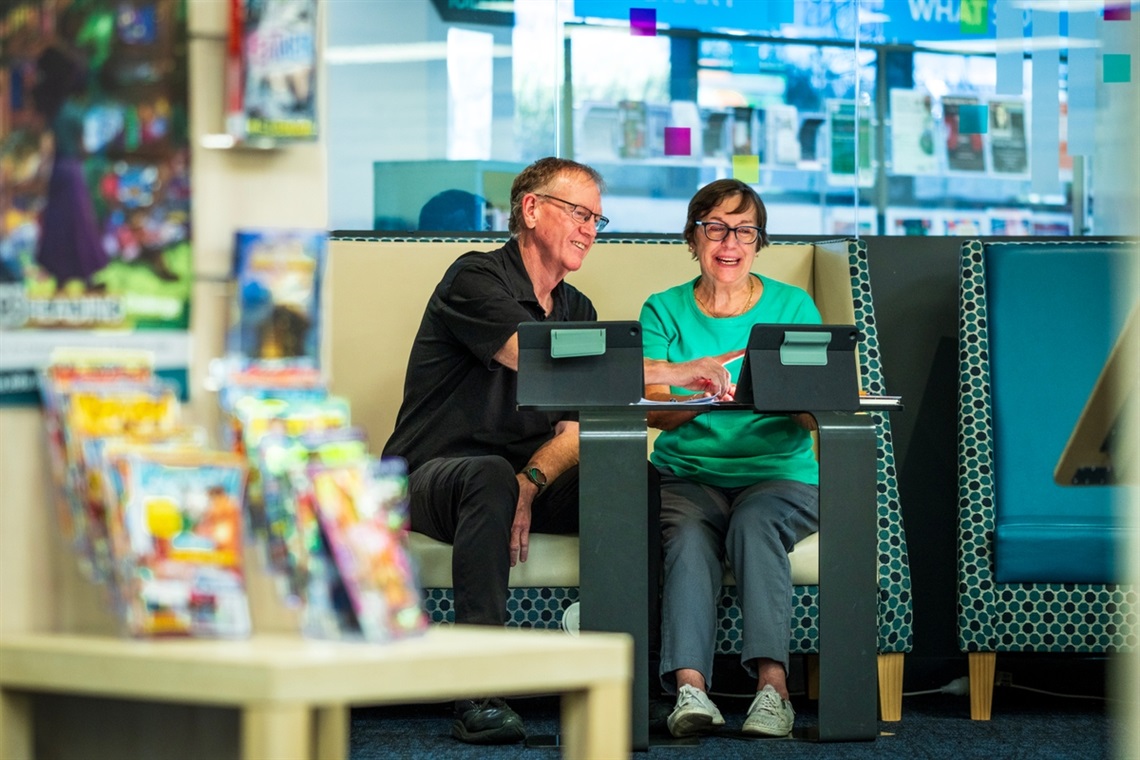Libraries staff member David with library member Maureen explore the capabilities of digital devices.