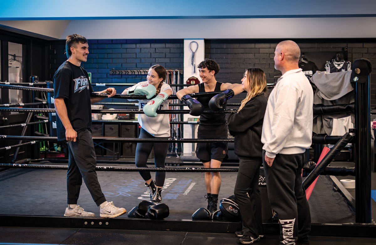 Jesse Jones from Jones Boxing Gym speaks with the Rahaley family (Alissa, Tyson, Skye and Daniel) in the ring.
