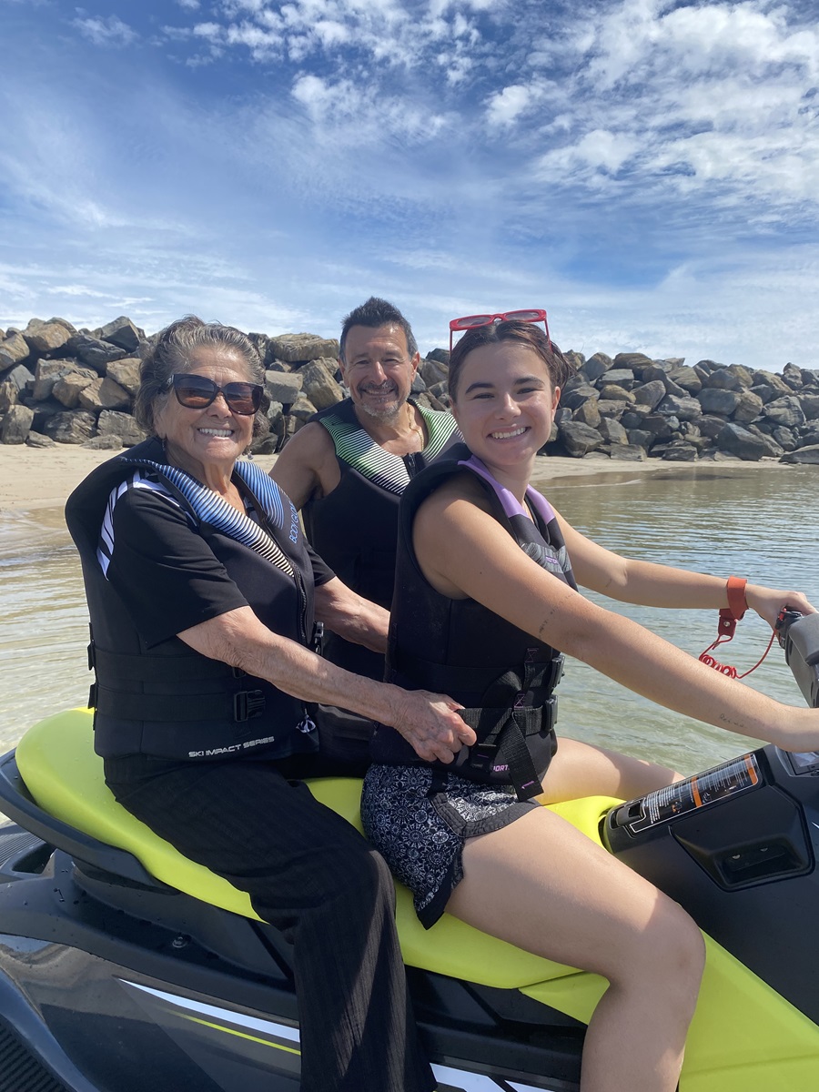 93-year-old woman Lola Gonzales sits behind her granddaughter, Amaya, on a jetski, with son-in-law Andrew behind them.
