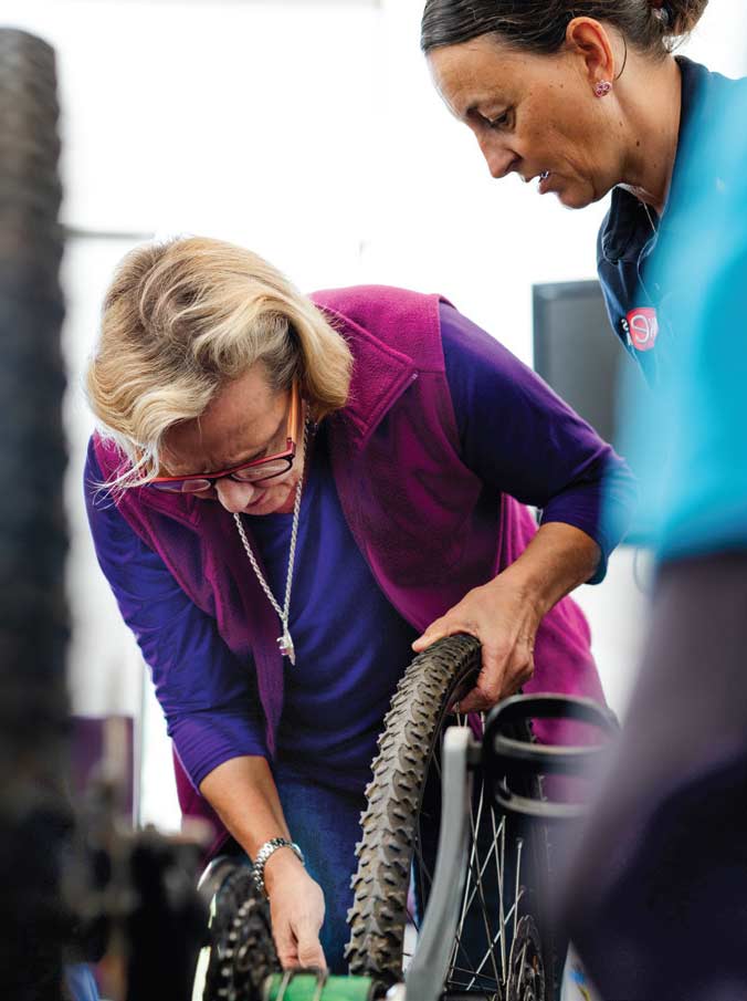 Participants at a Ride Her Way bike maintenance workshop practise fixing flat tyres.