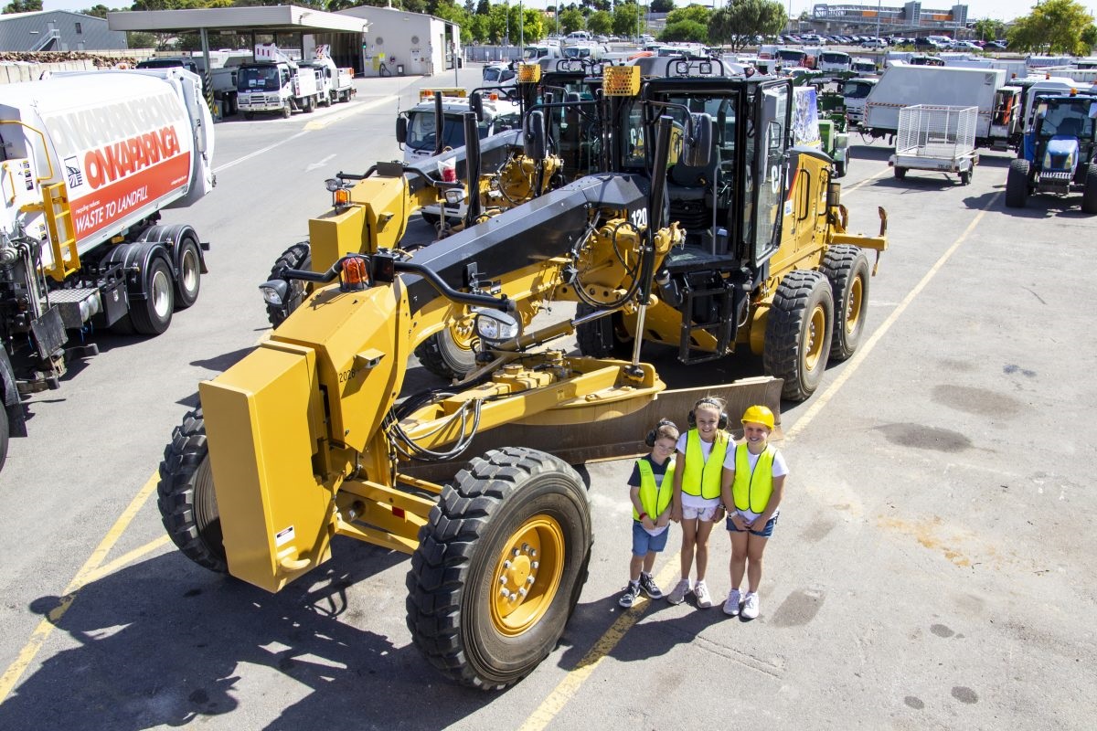 Ryder, Kobe and Lia standing in front of CAT truck