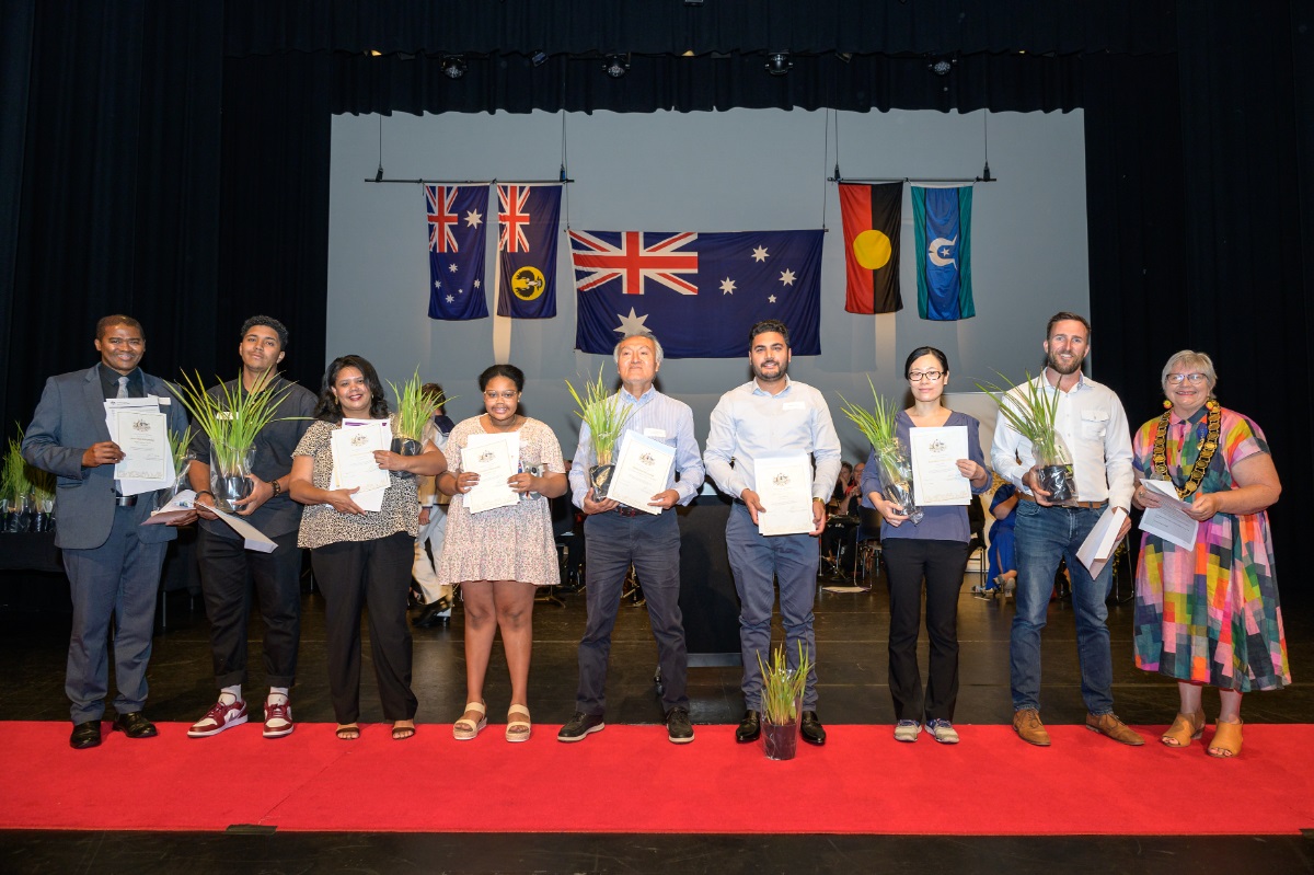 Some of Onkaparinga and Australia's newest citizens smile on stage with their certificates.